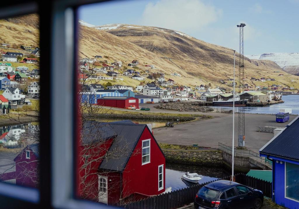 a view of a small town with a red house at Lovely 4 Bedroom House in Vestmanna in Vestmanna