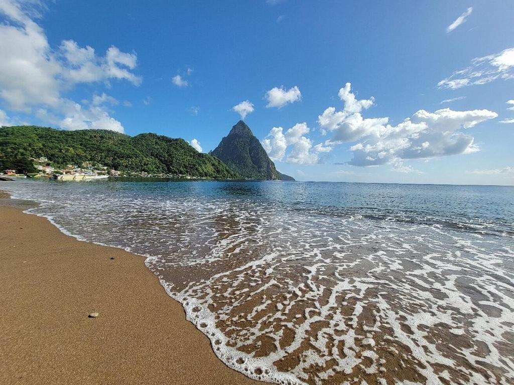 a view of a beach with a mountain in the background at Sea Piton View Apartment- Location, Convenience, Modern Living in Soufrière