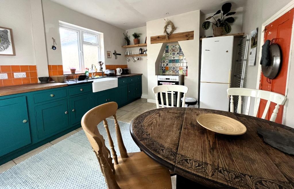 a kitchen with a wooden table and some chairs at Cottage Hideaway with Garden in Bristol