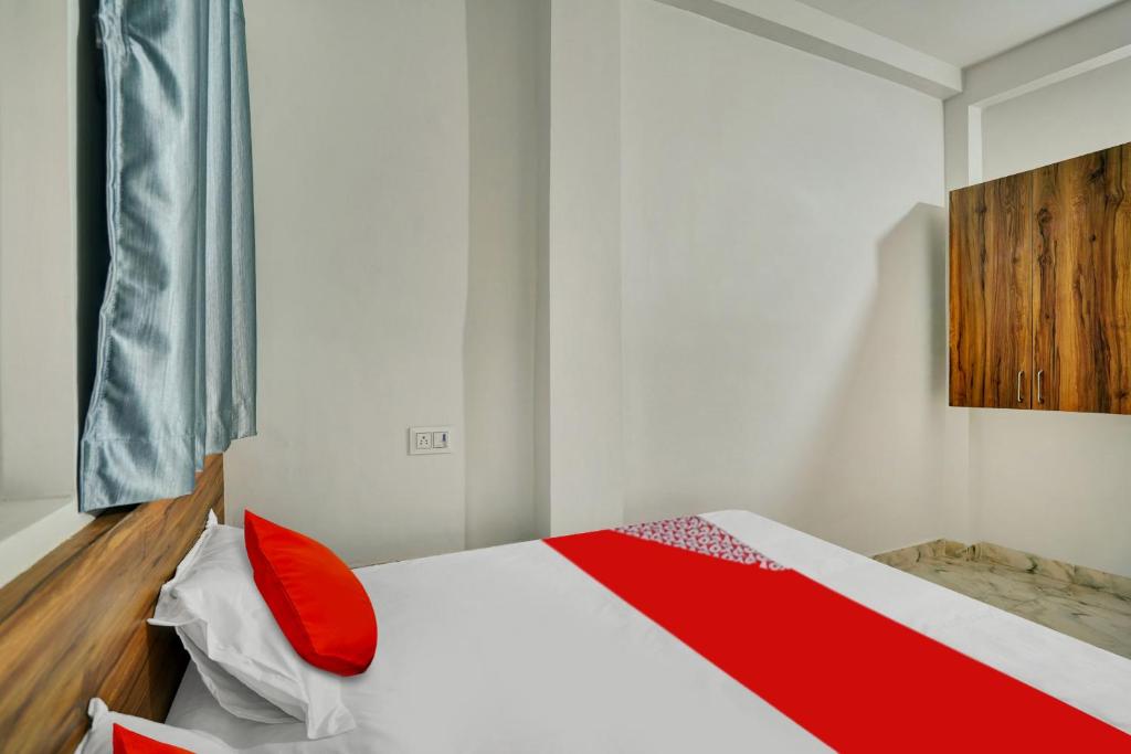 a bedroom with a bed with red pillows on it at OYO Flagship Hotel The Cloud in Bhilai