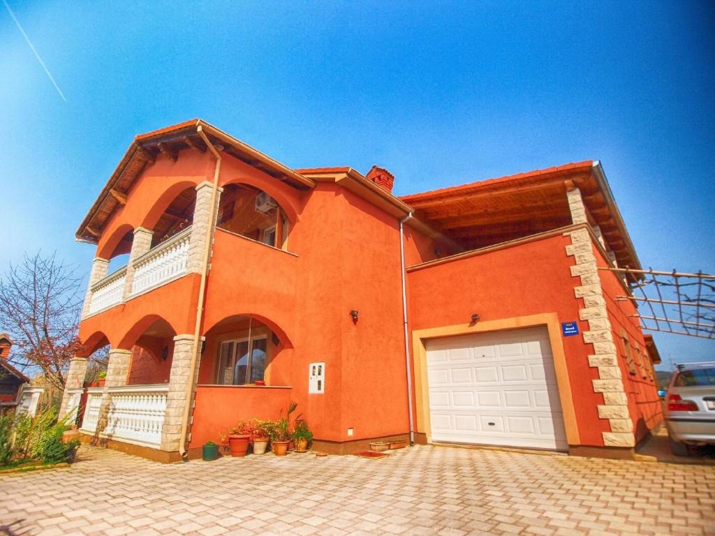 een oranje bakstenen huis met een witte garage bij Ferienwohnung für 5 Personen ca 70 qm in Pula, Istrien Istrische Riviera - b60851 in Pula