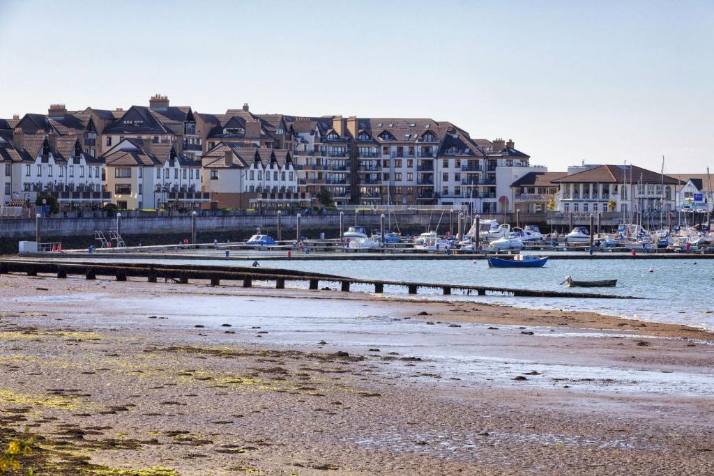 a beach with a pier and boats in the water at Grand Hotel in Malahide