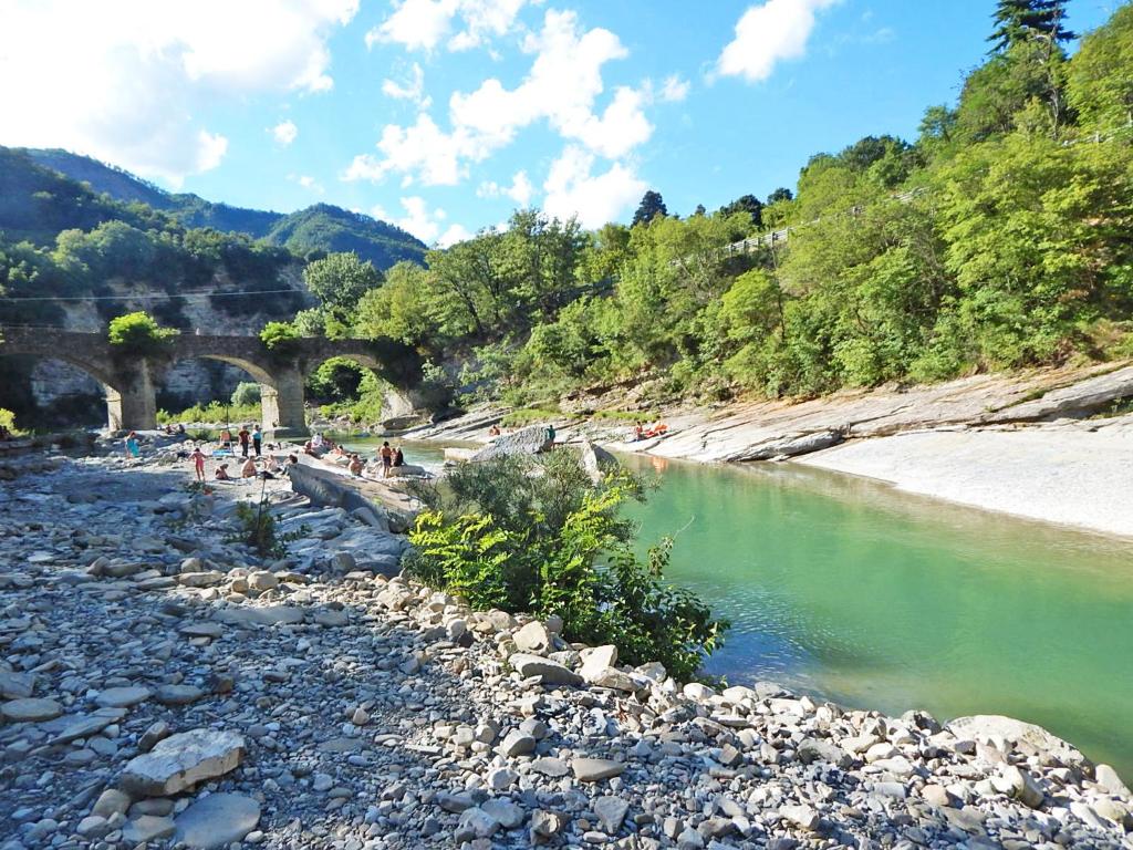 a group of people standing on a beach next to a river at Pieve di Cà Maggiore in Firenzuola