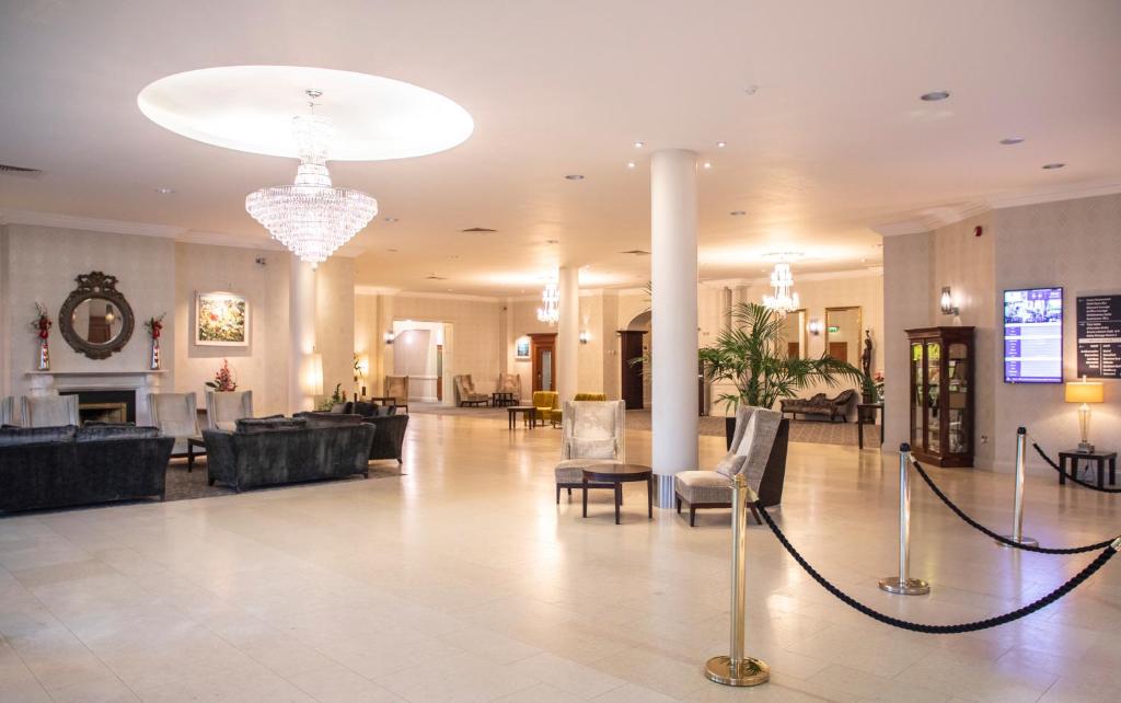 a lobby with couches and chairs and a chandelier at Grand Hotel in Malahide