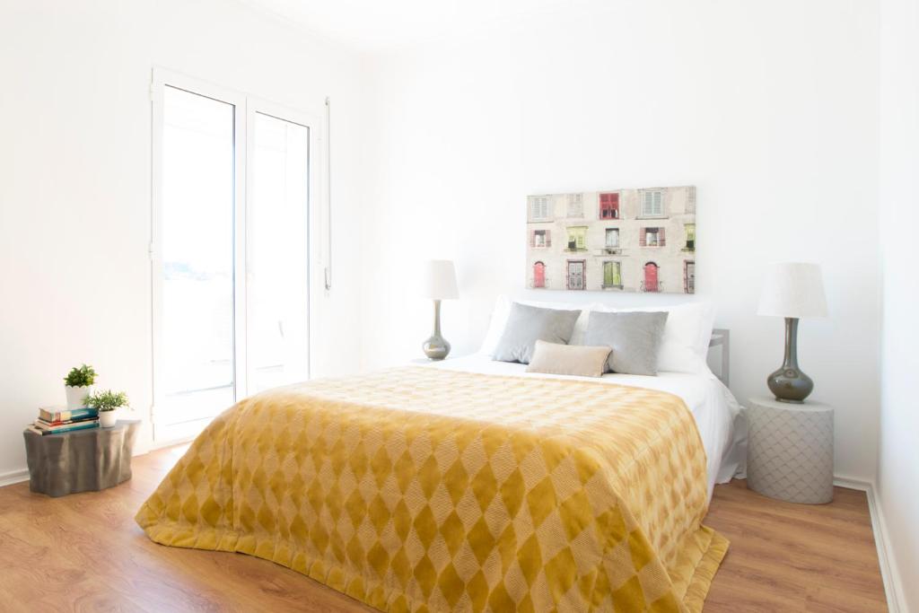 um quarto branco com uma cama com um cobertor amarelo em Fabulous Apartment at UNESCO World Heritage Center em Coimbra