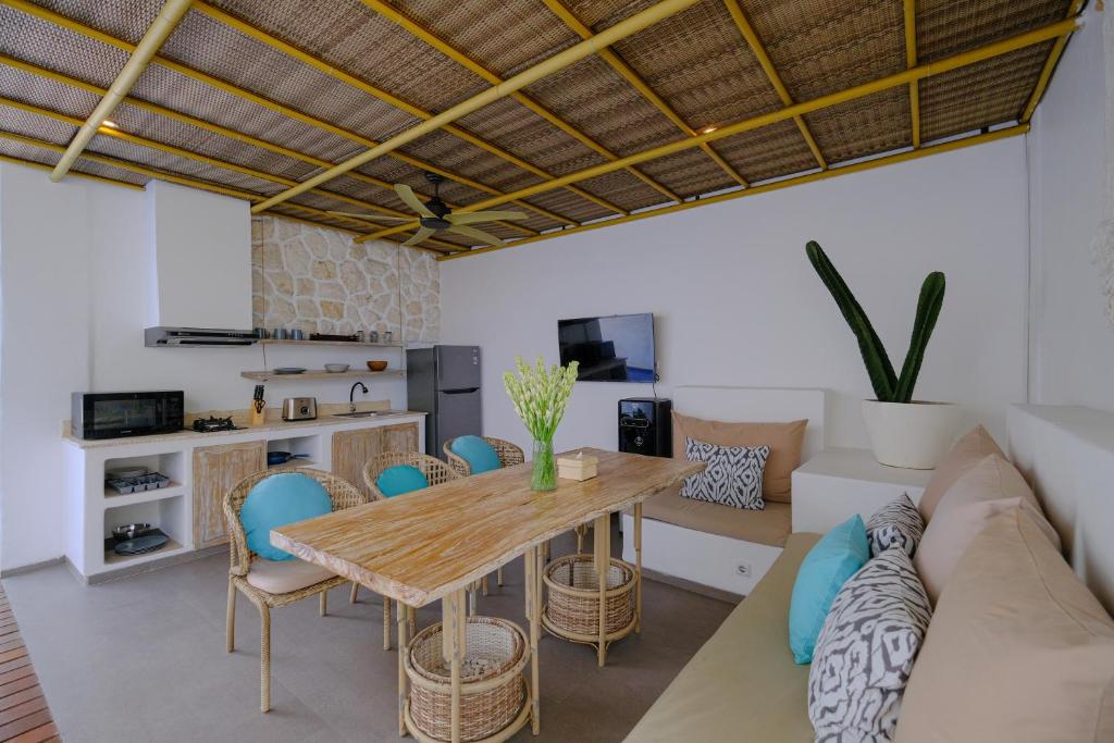 Una cocina y una sala de estar con una mesa y sillas de madera. en Villa Hanara - Unique 2BR Mediterranean, en Uluwatu