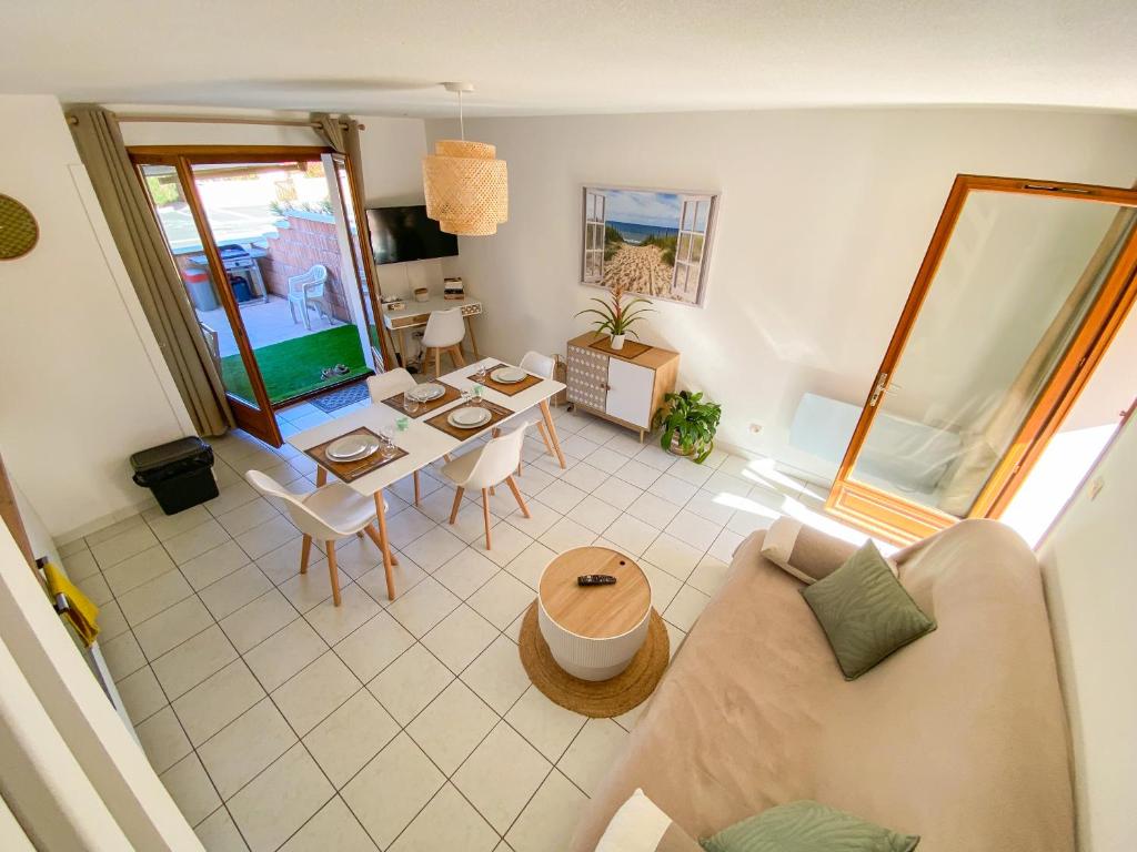 uma sala de estar com um sofá e uma mesa em Maison "Douceurs d'Été" em Vias