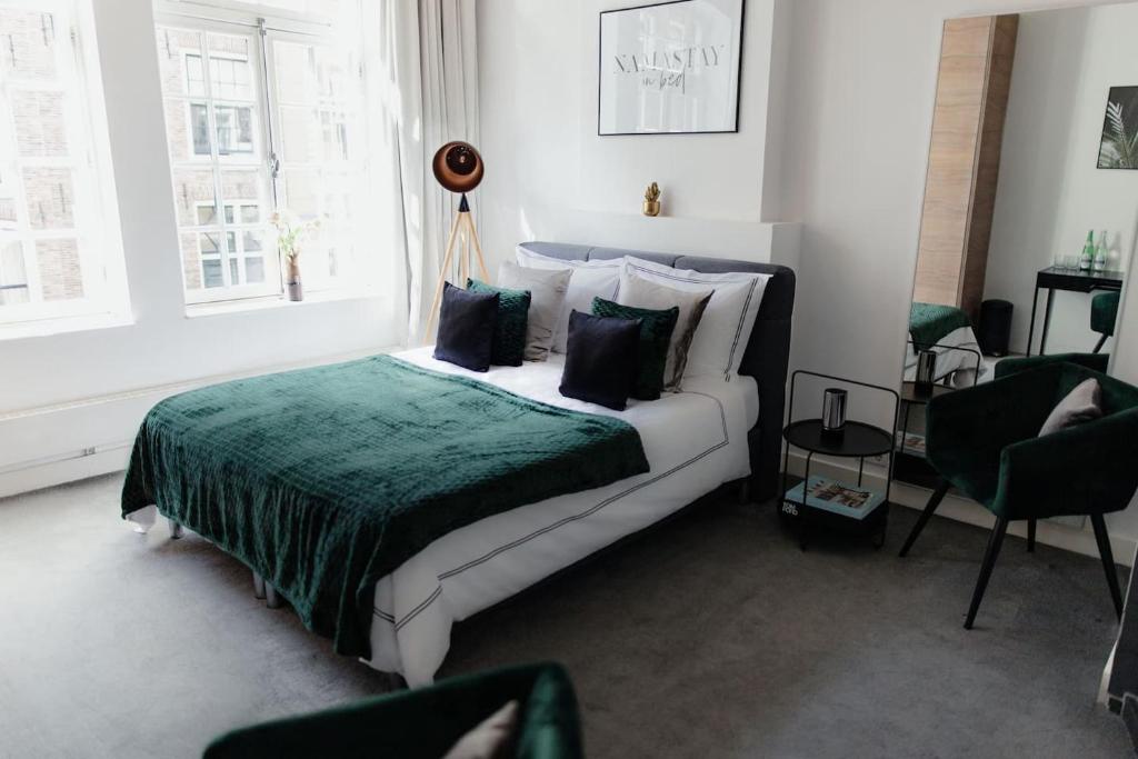 een slaapkamer met een bed met een groene deken bij Kerkstraat Residence in Amsterdam