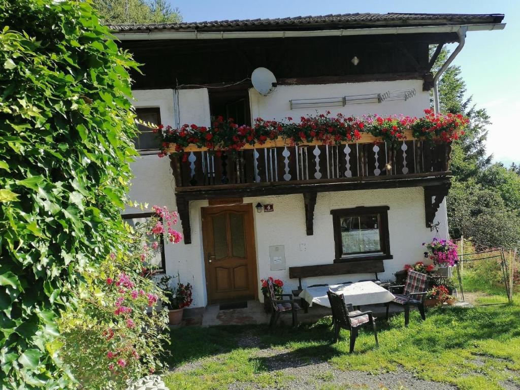 a house with a balcony with flowers on it at Ruhig am Waldrand gelegene Wohneinheit in Innsbruck