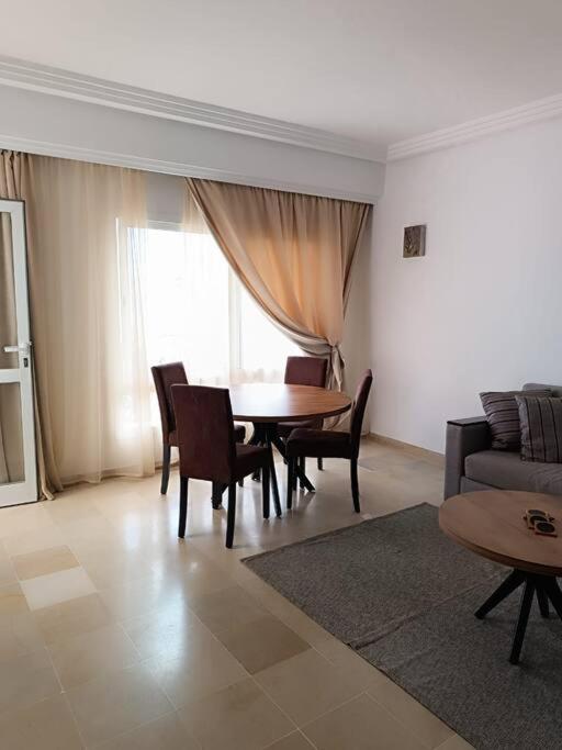 - un salon avec une table, des chaises et un canapé dans l'établissement Logement S+2 dans un hôtel 4* vue mer, à Bizerte
