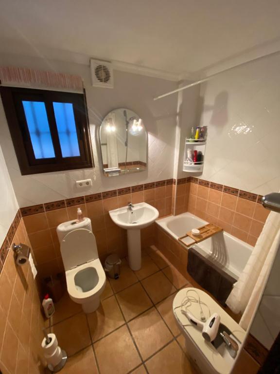a bathroom with a toilet and a sink and a tub at Ellaure in Monda