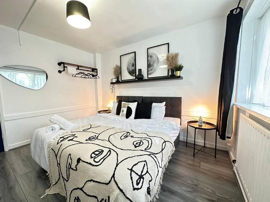 a bedroom with a bed with a black and white blanket at Cosy Retreat: Near Attractions & Comfortable! in Birmingham