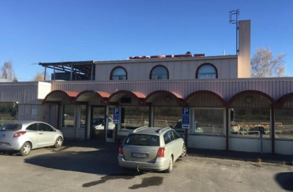 dos autos estacionados en un estacionamiento frente a un edificio en Liz Motell, en Sundsvall