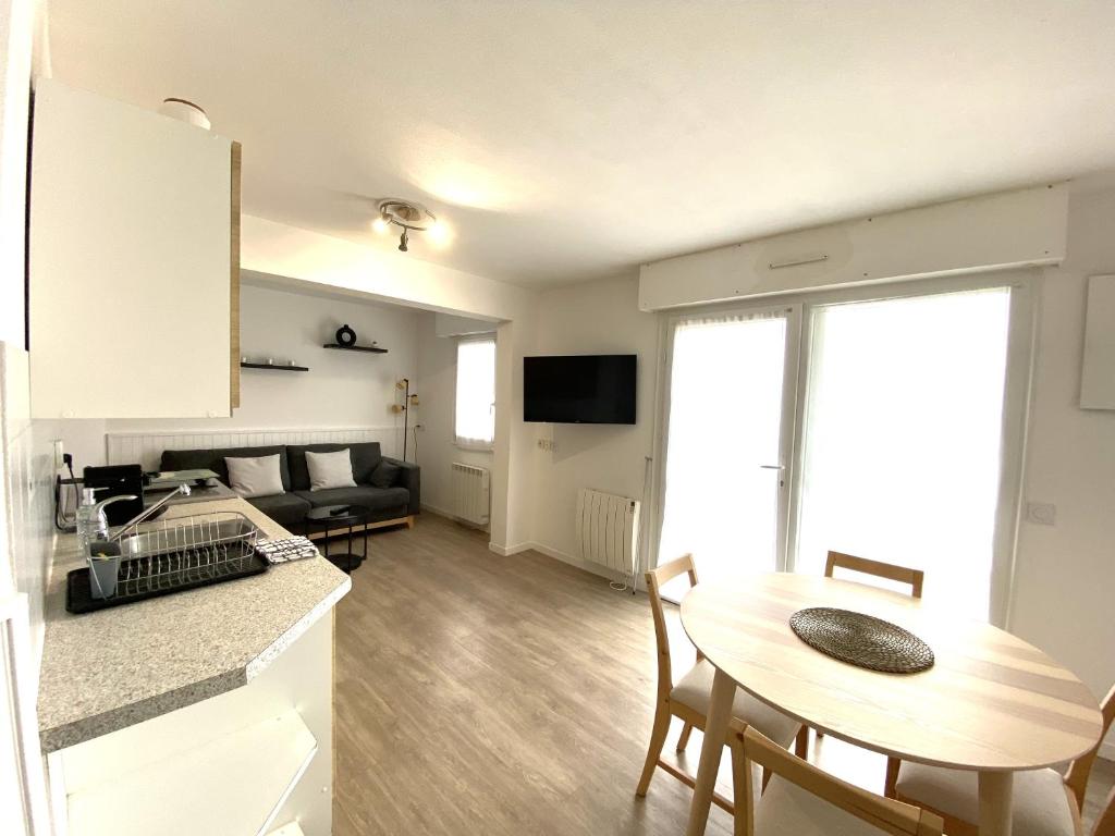 une cuisine et un salon avec une table et un canapé dans l'établissement Charmant appartement 2 à 4 personnes à 200m de la plage avec wifi - ALAN, à Ploemeur