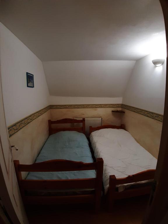 a small room with two beds in a attic at gîte des Templiers, appartement meublé pour 4 personnes à la campagne à 10min de la côte d&#39;opale et de la baie de Somme in Conchil-le-Temple