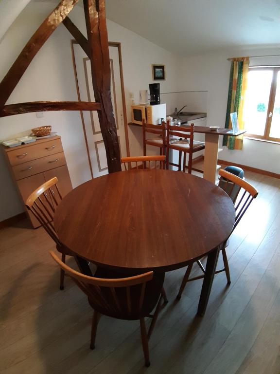 a wooden table and chairs in a room at gîte des Templiers, appartement meublé pour 4 personnes à la campagne à 10min de la côte d&#39;opale et de la baie de Somme in Conchil-le-Temple