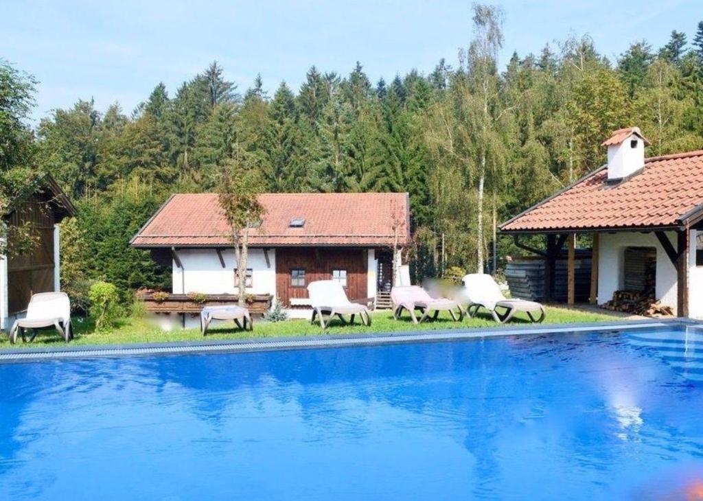 une villa avec une piscine et une maison dans l'établissement Wohnung in Hauzenberg mit Terrasse, gemeinsamem Pool und Garten, à Hauzenberg