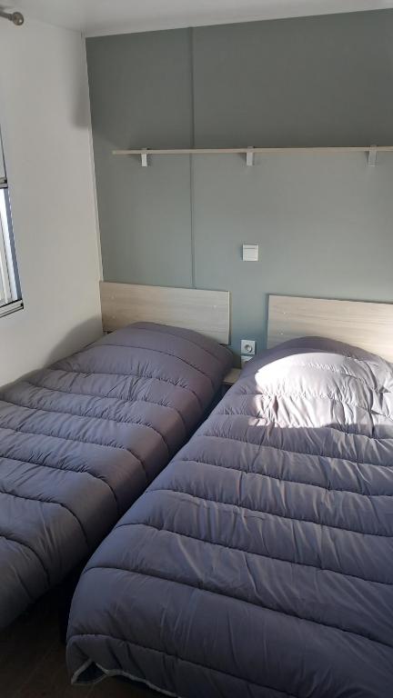 łóżko w pokoju z niebieskim kocem w obiekcie mobil home le castellas Bertrand /stehlin w mieście Sète