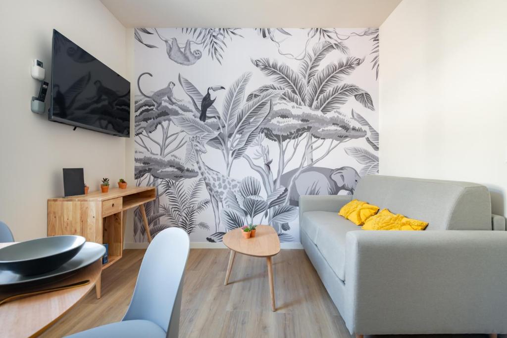 - un salon avec un canapé et une fresque murale dans l'établissement Origan * Cosy * Linge hôtelier * Fibre * Calme, à La Destrousse