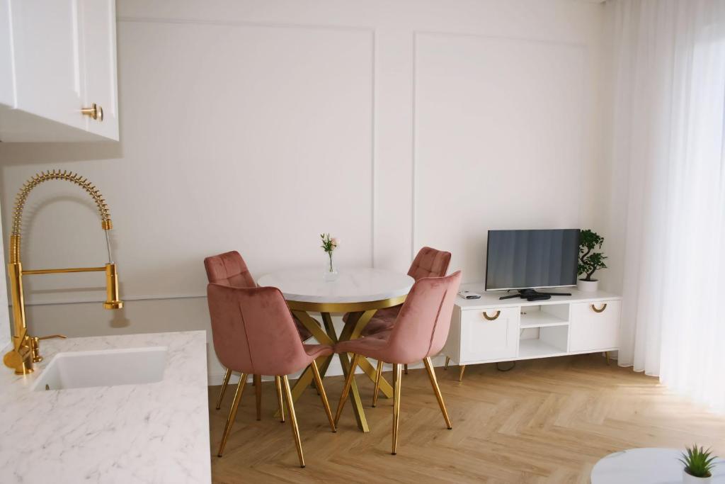 une cuisine avec une table et des chaises ainsi qu'une télévision dans l'établissement Apartament No.53, à Toruń