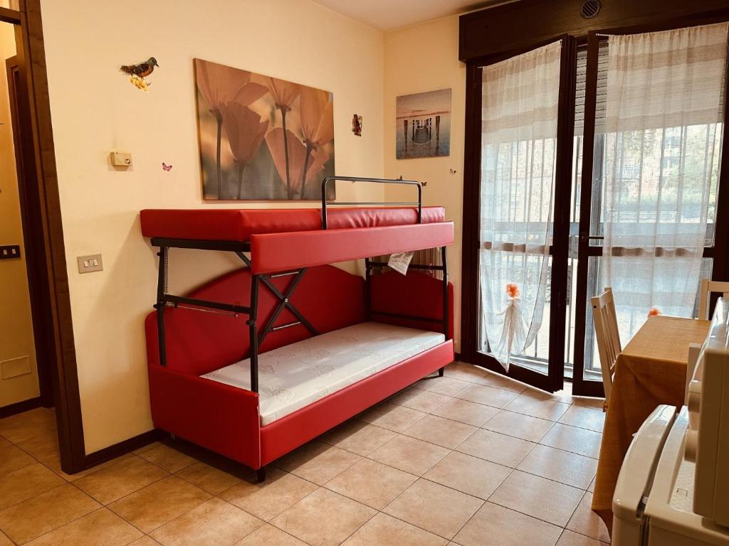 Letto a castello rosso in camera con finestra di CASA VACANZA RELAX a Reggio Emilia