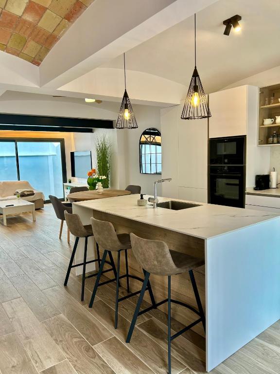 a kitchen and living room with a large island with chairs at La Repera in Palamós