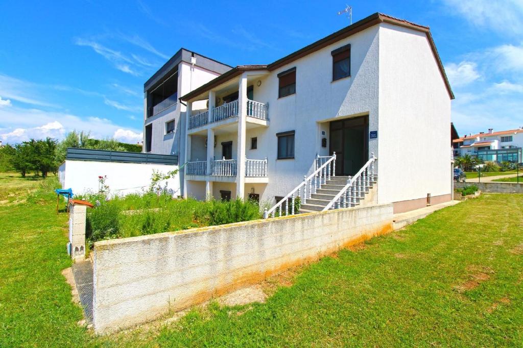 uma casa branca com uma parede de betão em Ferienwohnung für 4 Personen ca 50 qm in Pula-Fondole, Istrien Istrische Riviera - b61749 em Štinjan