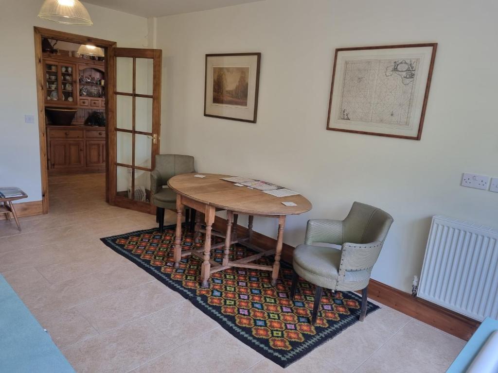 a dining room with a wooden table and chairs at Halcyon in Harrogate