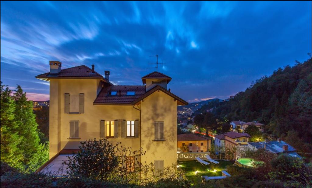 a house with a roof on top of it at night at The Villa Suites - Pool & SPA in Como