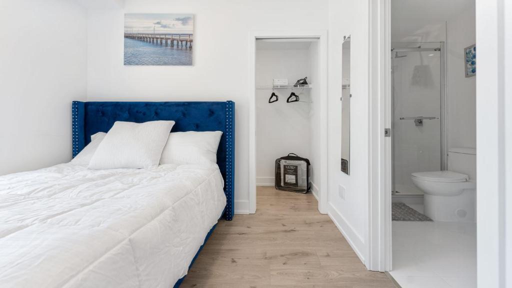 um quarto com uma cama com uma cabeceira azul e uma casa de banho em Luxury Suite 4mins To Falls em Cataratas do Niágara