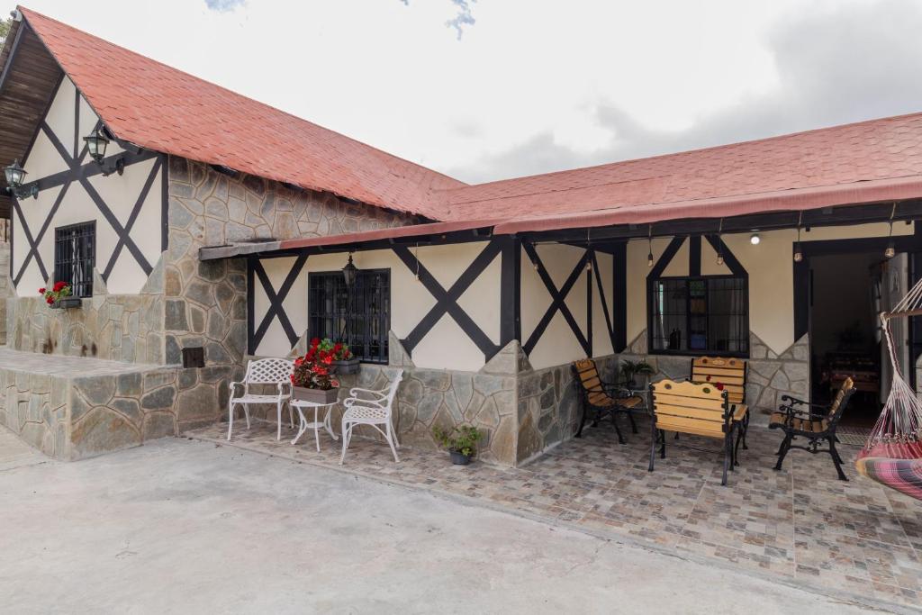 ein Steinhaus mit einem roten Dach und einer Terrasse in der Unterkunft Casa familiar en la colonia Tovar in El Tigre