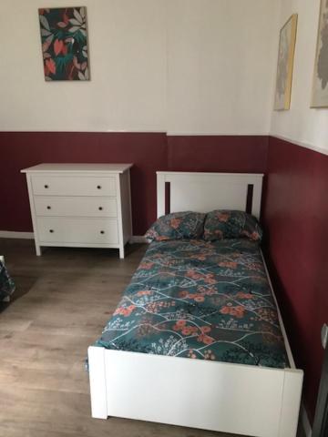 a bedroom with a white bed and a dresser at La clef Sithieu in Saint-Omer