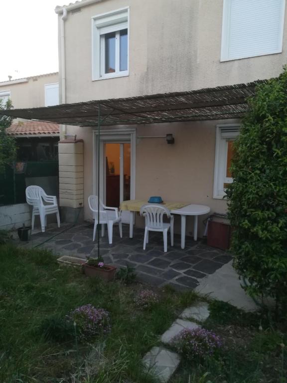 d'une terrasse avec une table, des chaises et une table. dans l'établissement maison T4, confort, bord de l'étang,10 mn du centre, avec jardin, à Sète