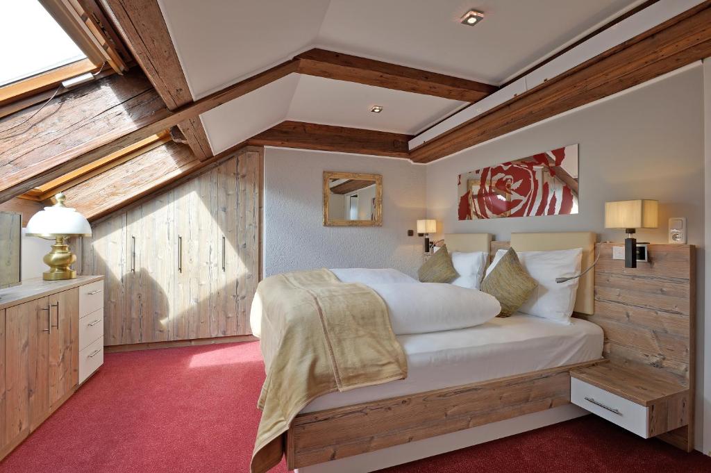 a bedroom with a large white bed with wooden walls at Hotel Kufsteinerhof in Kufstein