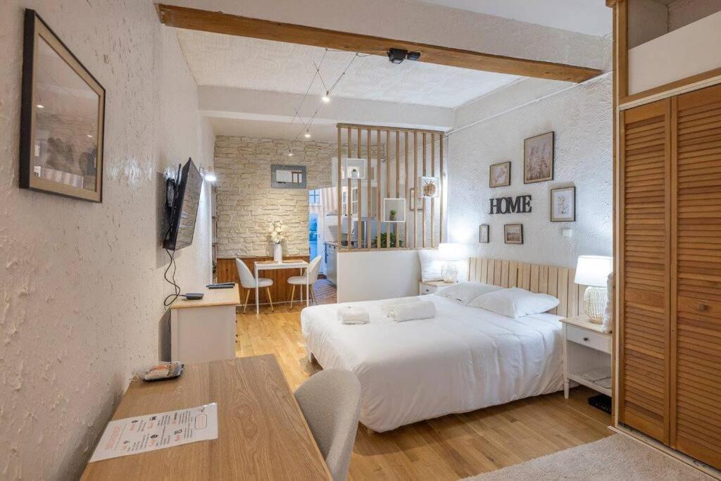 een slaapkamer met een wit bed en een tafel bij Studio entièrement rénové dans les rue piétonnes in Grenoble