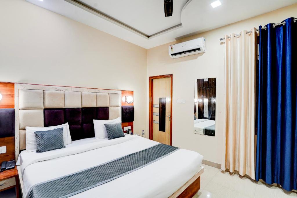1 dormitorio con 1 cama blanca grande y cortinas azules en Yoga Homestay en Agra