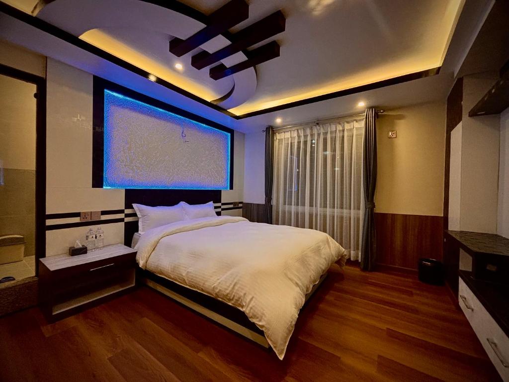 a bedroom with a large bed and a large window at Pine Tree Resort in Bhaktapur