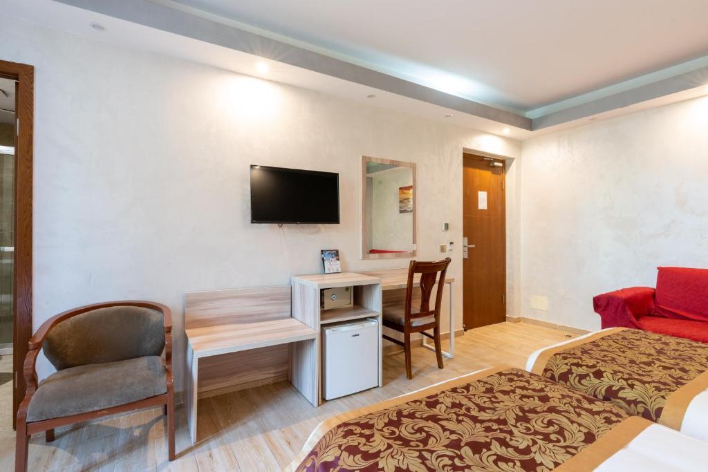 Cette chambre comprend deux lits et un bureau. dans l'établissement Leoni D'oro - close to Roma Termini, à Rome