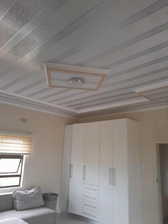 a ceiling in a room with a bed and cabinets at PHIL M AND PARTNERS ESTATES. in Manzini