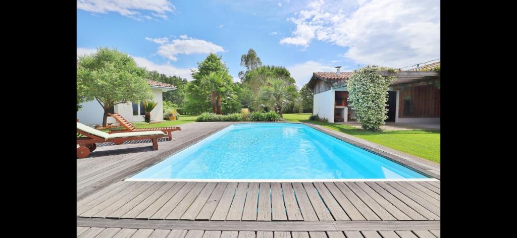 una piscina en un patio con terraza de madera en Le spot Landais - Côté piscine, en Soustons
