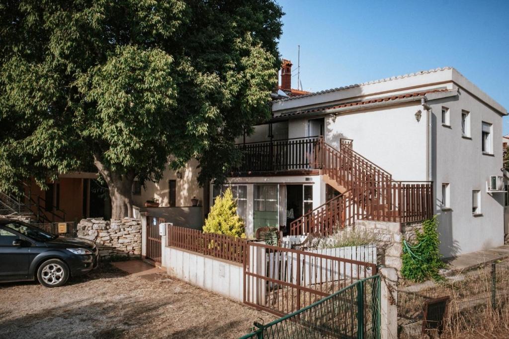 ein Haus mit einem Zaun und einem Auto vor dem Haus in der Unterkunft Studio für 4 Personen ca 42 qm in Peroj, Istrien Istrische Riviera in Peroj