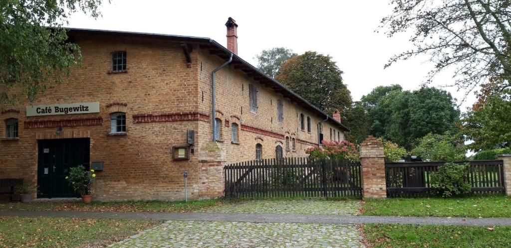 a brick building with a gate in front of it at Kleine Ferienwohnung in Bugewitz mit Garten, Terrasse und Grill in Bugewitz