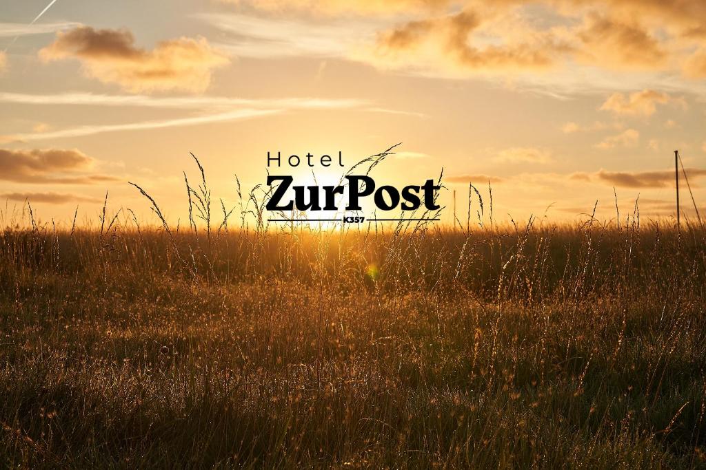 un campo de hierba alta con un cartel de hotel zent en K357 - Hotel & Restaurant "Zur Post" in Otterndorf bei Cuxhaven en Otterndorf