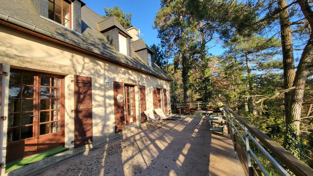 un bâtiment avec un banc devant lui dans l'établissement 710 - Maison 6p à 450m de la plage de Lanruen., à Erquy