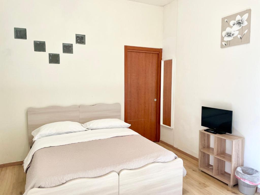 Habitación blanca con cama y TV en Casa di Magda2, en Reggio Calabria