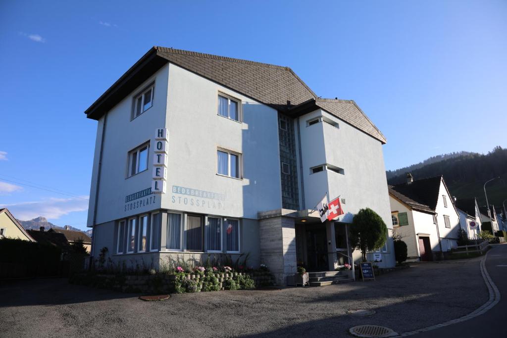 a white building with a sign on it at Hotel B&B Stossplatz in Appenzell