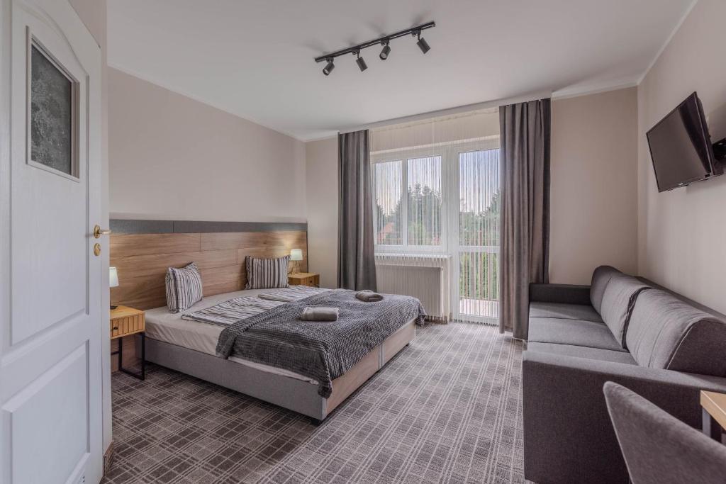un dormitorio con una cama y un sofá en Dom Pracy Twórczej, en Świnoujście