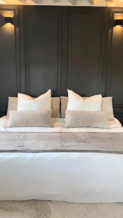 a bed with white pillows on top of it at Amazing view on the Versailles Palace - Paris 15min in Versailles