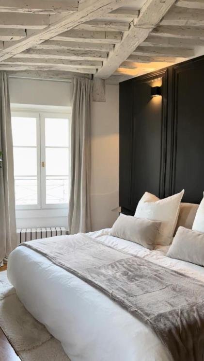 a large white bed in a room with a window at Amazing view on the Versailles Palace - Paris 15min in Versailles