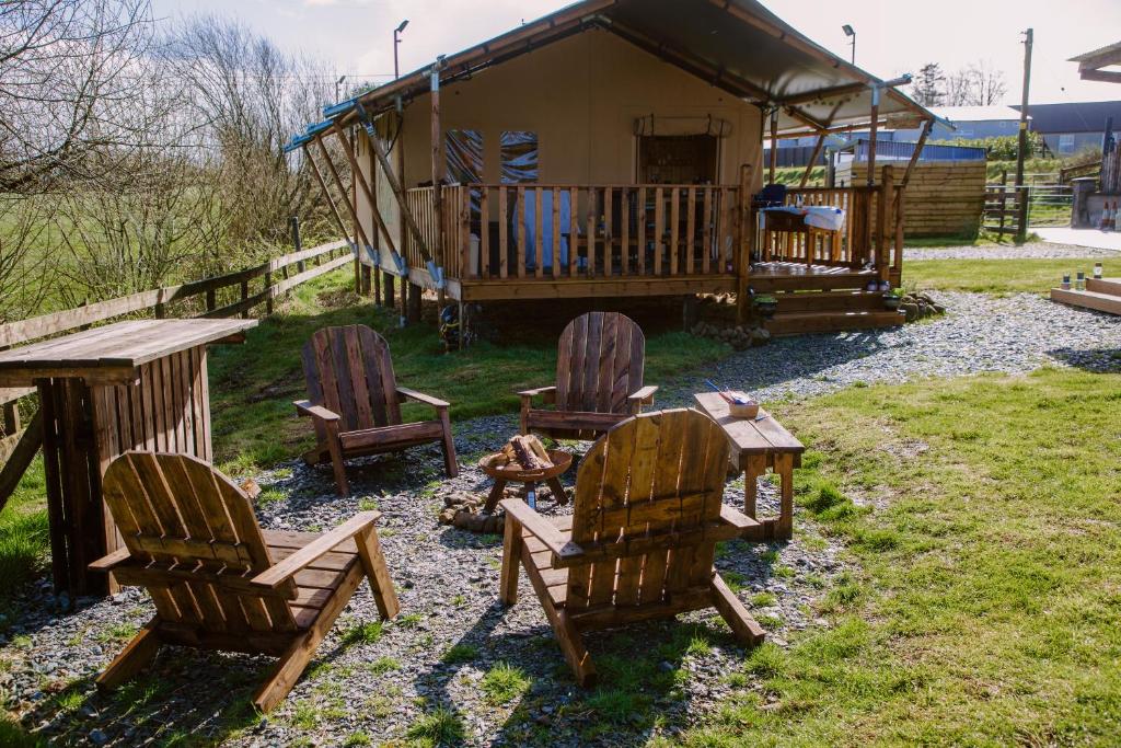 a group of chairs sitting in front of a cabin at Rosgarron Safari Canvas Lodge Glorious Glamping in Magherafelt